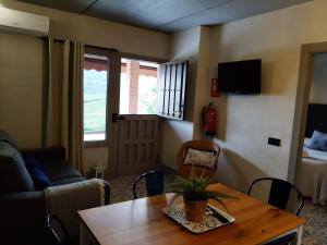 a living room with a table and a couch at Apartamentos El Llanin in Cangas de Onís