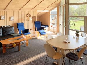 a living room with a table and blue chairs at Holiday home Nakskov VI in Nakskov