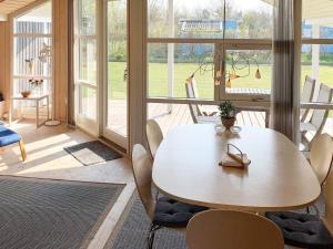 a table and chairs in a room with a large window at Holiday home Nakskov VI in Nakskov