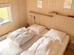 two beds in a room with white sheets at Holiday home Nakskov VI in Nakskov