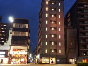 a tall building in a city at night at THE POCKET HOTEL Kyoto Karasuma Gojo in Kyoto