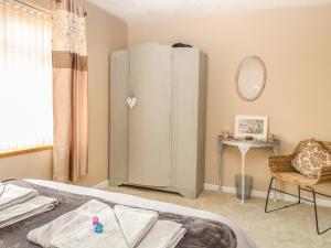 ein Schlafzimmer mit einem Kühlschrank in der Ecke eines Zimmers in der Unterkunft The Haven in Great Moulton