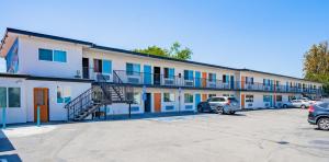 a large building with cars parked in a parking lot at Tradewinds Motel in Lakewood