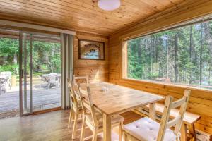 a dining room with a table and chairs and a large window at Sweet Retreat Cabin in Leavenworth
