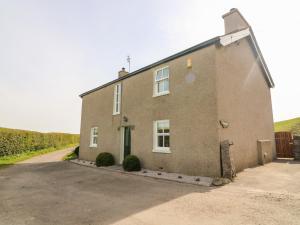 a large brick building with a green door at Waingate Cottage in Cark