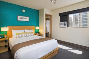 1 dormitorio con 1 cama grande y pared azul en VIVE Hotel Waikiki en Honolulu