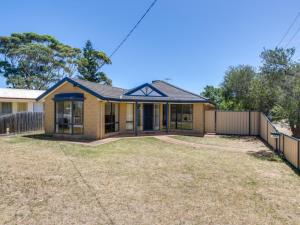 a house with a fence in front of it at Stones Throw To The Beach in Tootgarook