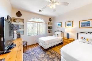 ein Schlafzimmer mit zwei Betten und einem Flachbildfernseher in der Unterkunft Vistoso Casitas Golf II #210B in Tortolita + 26 Fotos