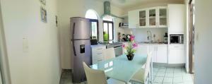 a kitchen with a stainless steel refrigerator and white cabinets at FABULOSA CASA Centro Cuernavaca Alberca Privada Climatizada in Cuernavaca