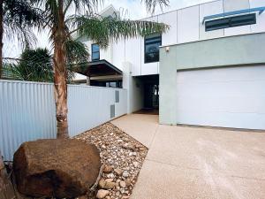 a house with a palm tree next to a driveway at RL Apartments in Moama