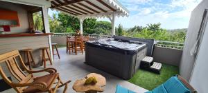 a patio with a grill and a table and chairs at Residence Can' Hibiscus in Le Marin