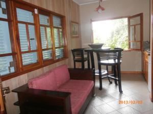 a living room with a couch and a table and chairs at Demeure de Cap Macon in Takamaka