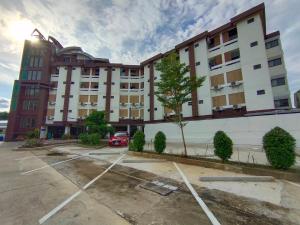 a building with a car parked in a parking lot at Aileen Hotel in Khon Kaen