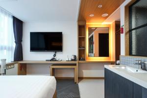 pokój hotelowy z łóżkiem, telewizorem i umywalką w obiekcie S Stay Hotel w mieście Suwon