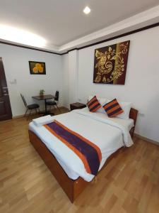 ein Schlafzimmer mit einem großen Bett und einem Tisch in der Unterkunft WeRest Hotel in Khon Kaen