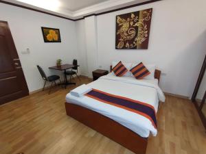ein Schlafzimmer mit einem Bett und einem Tisch darin in der Unterkunft WeRest Hotel in Khon Kaen