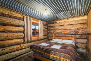 1 dormitorio con 1 cama en una cabaña de madera en Dargo Hotel, en Dargo