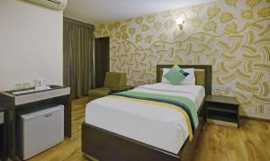 a hotel room with a bed and a desk at Treebo Savoury Sea Shell Residency in Bengaluru