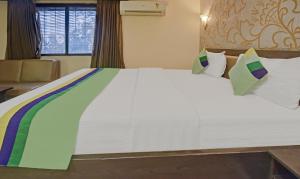 a bedroom with a large white bed with pillows at Treebo Savoury Sea Shell Residency in Bengaluru