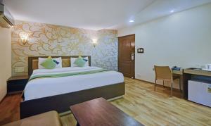 a hotel room with a bed and a table and a desk at Treebo Savoury Sea Shell Residency in Bengaluru