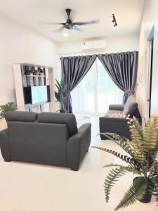 uma sala de estar com dois sofás e uma televisão em Private pool Cassa Dinies, Wifi , Bbq,10 pax em Rantau Panjang