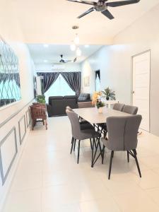 a dining room and living room with a table and chairs at Private pool Cassa Dinies, Wifi , Bbq,10 pax in Rantau Panjang