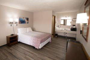 Shady Rest Motel في Arapahoe: غرفة الفندق بسرير ومغسلة