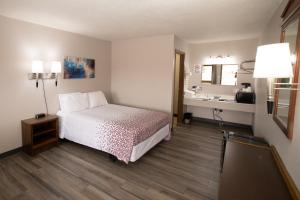 ein Hotelzimmer mit einem Bett und einem Waschbecken in der Unterkunft Shady Rest Motel in Arapahoe
