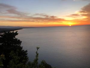 a sunset over the water with the sun in the sky at Luna Convento Copanello B&B in Stalettì