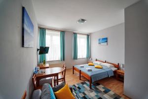 a living room with a bed and a table and a couch at Hotelik Gołdap in Gołdap