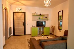 een woonkamer met een bank en een flatscreen-tv bij Orizont sea view Apartment- Spa n Pools beach resort in Mamaia