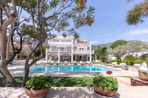 an exterior view of a large house with a swimming pool at The Manor in Paleo Tsifliki