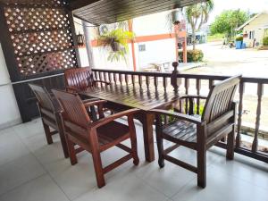 una mesa de madera y 2 sillas en el porche en Baan Kaew Ruen Kwan, en Jomtien Beach
