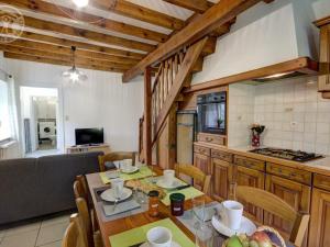 eine Küche und ein Esszimmer mit einem Tisch und Stühlen in der Unterkunft Gîte Apinac, 3 pièces, 4 personnes - FR-1-496-122 in Apinac