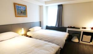 una camera d'albergo con due letti e una finestra di Hotel Thomas Myeongdong a Seul