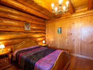 Un dormitorio con una cama en una cabaña de troncos en Chalet de charme avec étang privé : pêche, nature et détente au cœur du Périgord - FR-1-616-72, en Dussac