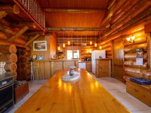 una cocina con una gran mesa de madera en una cabaña en Chalet de charme avec étang privé : pêche, nature et détente au cœur du Périgord - FR-1-616-72, en Dussac