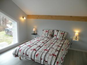 a bedroom with a bed with a comforter and a window at Gîte Le Tholy, 4 pièces, 6 personnes - FR-1-589-158 in Le Tholy