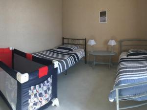 2 Betten in einem Zimmer mit einem Tisch und 2 Betten in der Unterkunft Gîte Migné, 3 pièces, 4 personnes - FR-1-591-316 in Migné
