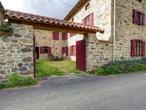 a stone building with red windows and a red door at Gîte Saint-Just-en-Bas, 4 pièces, 6 personnes - FR-1-496-19 in Saint-Just-en-Bas