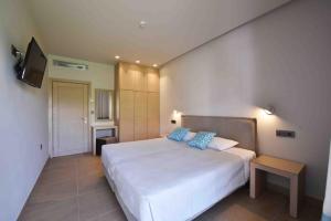 a bedroom with a large white bed with blue pillows at MIRAMARE LUXURY APARTMENTS in Eretria