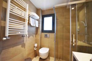 a bathroom with a toilet and a glass shower at MIRAMARE LUXURY APARTMENTS in Eretria