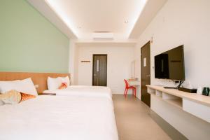 馬公市的住宿－向日葵精緻旅店，一间酒店客房,设有两张床和电视