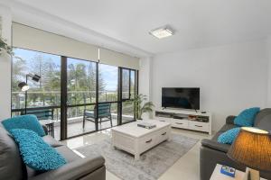 Una sala de estar con un sofá y un televisor. en Holiday Central, Tasman Towers Unit 2, 3 Munster Street,, en Port Macquarie