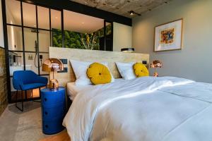 a bedroom with a large white bed with yellow pillows at KONCEPT HOTEL International in Cologne