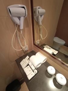 uma casa de banho com um telefone, um lavatório e um WC. em Swiss-Belresidences Kalibata em Jacarta