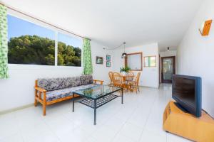 een woonkamer met een bank, een tafel en een tv bij Apartamento Grillo in Cala Ratjada