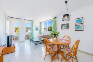 a living room with a table and chairs and a tv at Apartamento Grillo in Cala Ratjada