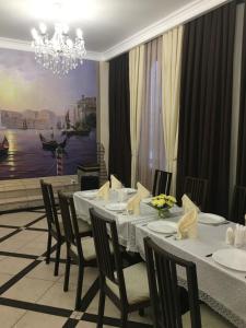 a dining room with a table and chairs and a chandelier at Hotel Elegia in Trostyanetsʼ