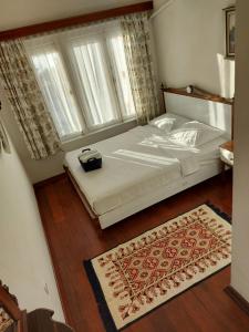 a bedroom with a bed and a large window at Celil Pansiyon in Ayvalık
